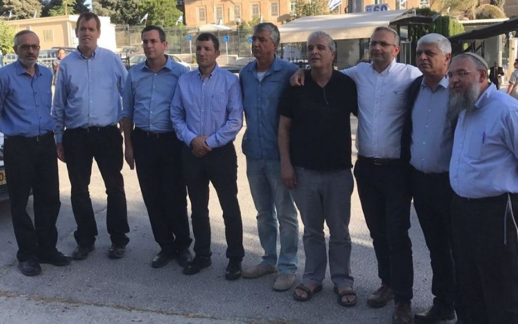 Les chefs des implantations posent pour une photo près du bureau du Premier ministre suite à leur rencontre avec Benjamin Netanyahu le 7 juin 2017. De gauche à droite, 2017. le président du conseil régional de Gush Etzion Shlomo Neeman, le maire de Maale Adumim Benny Kasriel, le président du conseil local de Beit El Shai Alon, le président du conseil de Yesha Avi Roeh, le maire de Karnei Shomron Yigal Lahav, le directeur général du conseil de Yesha Shiloh Adler, le maire d'Elkana Asaf Mintzer, et le chef du conseil local de Kiryat Arba Malachi Levinger. (Crédit : Jacob Magid/Times of Israel) Les chefs des implantations posent pour une photo près du bureau du Premier ministre suite à leur rencontre avec Benjamin Netanyahu le 7 juin 2017. De gauche à droite, 2017. le président du conseil régional de Gush Etzion Shlomo Neeman, le maire de Maale Adumim Benny Kasriel, le président du conseil local de Beit El Shai Alon, le président du conseil de Yesha Avi Roeh, le maire de Karnei Shomron Yigal Lahav, le directeur général du conseil de Yesha Shiloh Adler, le maire d'Elkana Asaf Mintzer, et le chef du conseil local de Kiryat Arba Malachi Levinger. (Crédit : Jacob Magid/Times of Israel)