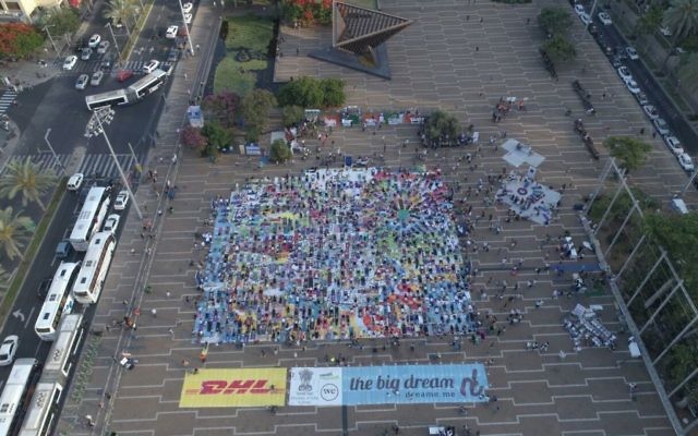 Vue aérienne de la plus grande installation artistique en tapis de yoga au monde, illustrée par Amit Trainin pour représenter Israël en 2018, à l'occasion de la 3e Journée internationale du Yoga à Tel Aviv, le 21 juin 2017. (Crédit : Guy Mador/skylens) Vue aérienne de la plus grande installation artistique en tapis de yoga au monde, illustrée par Amit Trainin pour représenter Israël en 2018, à l'occasion de la 3e Journée internationale du Yoga à Tel Aviv, le 21 juin 2017. (Crédit : Guy Mador/skylens)