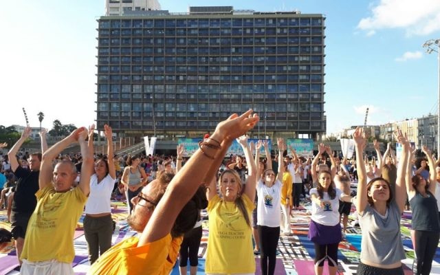 Des centaines de personnes sur la plus grande installation artistique en tapis de yoga au monde, illustrée par Amit Trainin pour représenter Israël en 2018, à l'occasion de la 3e Journée internationale du Yoga à Tel Aviv, le 21 juin 2017. (Crédit : Guy Mador/skylens) Des centaines de personnes sur la plus grande installation artistique en tapis de yoga au monde, illustrée par Amit Trainin pour représenter Israël en 2018, à l'occasion de la 3e Journée internationale du Yoga à Tel Aviv, le 21 juin 2017. (Crédit : Guy Mador/skylens)