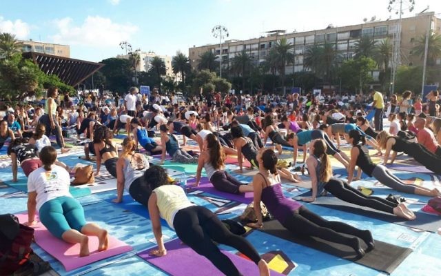 Des centaines de personnes sur la plus grande installation artistique en tapis de yoga au monde, illustrée par Amit Trainin pour représenter Israël en 2018, à l'occasion de la 3e Journée internationale du Yoga à Tel Aviv, le 21 juin 2017. (Crédit : Guy Mador/skylens) Des centaines de personnes sur la plus grande installation artistique en tapis de yoga au monde, illustrée par Amit Trainin pour représenter Israël en 2018, à l'occasion de la 3e Journée internationale du Yoga à Tel Aviv, le 21 juin 2017. (Crédit : Guy Mador/skylens)