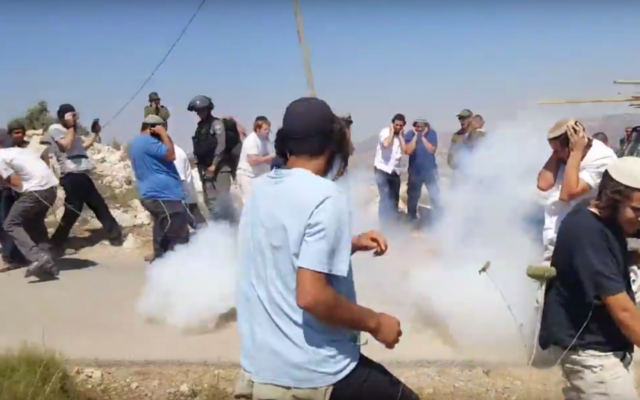 Des habitants de l'implantation de Yitzhar affrontent les forces de sécurité pendant la démolition d'une structure illégale, le 25 juin 2017. (Crédit : capture d'écran YouTube)