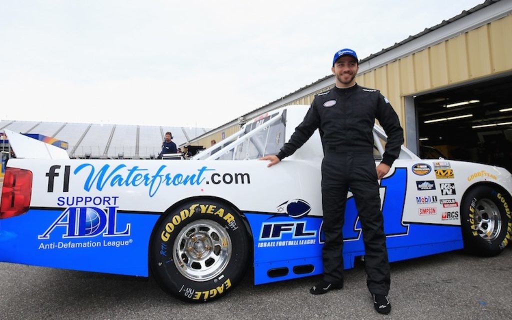 Alon Day, pilote d'une chevrolet sponsorisée par  FLwaterfront.com et qui porte le numéro 71, pose lors des  Camping World Truck Series UNOH 175 sur le circuit automobile du  New Hampshire le 23 septembre 2016 à Loudon, dans le New Hampshire. (Crédit : Chris Trotman/NASCAR via Getty Images/JTA)
