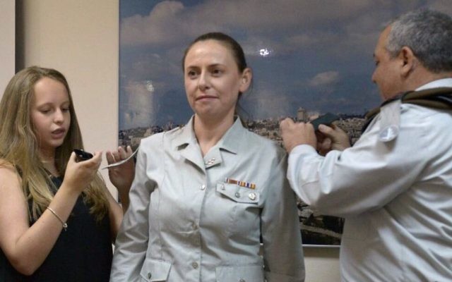Le brigadier-général de l'armée israélienne Ariella Lazrovitch reçoit son nouveau grade du chef d'Etat major de l'armée israélienne Gadi Eiesnkot et de sa fille, ainsi que son nouveau poste de conseillère économique en chef de l'armée le 27 juillet 2017. (Crédit : Unité du porte-parole de l'armée IDF ) Le brigadier-général de l'armée israélienne Ariella Lazrovitch reçoit son nouveau grade du chef d'Etat major de l'armée israélienne Gadi Eiesnkot et de sa fille, ainsi que son nouveau poste de conseillère économique en chef de l'armée le 27 juillet 2017. (Crédit : Unité du porte-parole de l'armée IDF )