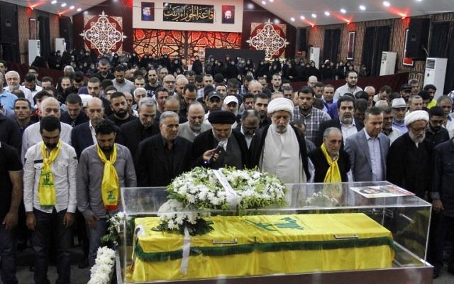 Des religieux et des membres du Hezbollah se recueillent sur le cercueil d'un médiateur tué à Jouroud Arsal, à la frontière syrienne, le 23 juillet 2017. (Crédit : AFP PHOTO / STRINGER)