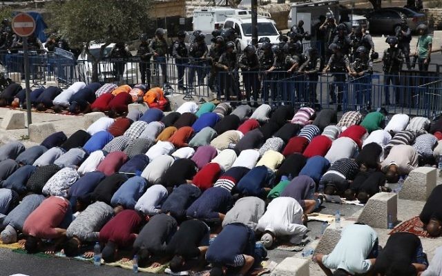 Les gardes-frontières israéliens surveillent les fidèles musulmans palestiniens qui prient en dehors de la Vieille mille de Jérusalem surplombant le mont du Mont du Temple le 28 juillet 2017 (Crédit : AFP PHOTO / AHMAD GHARABLI) Les gardes-frontières israéliens surveillent les fidèles musulmans palestiniens qui prient en dehors de la Vieille mille de Jérusalem surplombant le mont du Mont du Temple le 28 juillet 2017 (Crédit : AFP PHOTO / AHMAD GHARABLI)