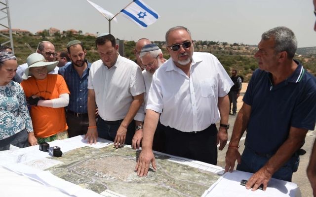 Le ministre de la Défense Avigdor Liberman présente son plan qui permettrait l'epansion de la ville de  Qalqilya dans la zone actuellement contrôlée par Israël durant une visite dans l'implantation de Maale Shomron le 12 juillet 2017 (Crédit : Eden Moldavski/Defense Ministry)