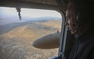 Le Premier ministre israélien Benjamin Netanyahu regarde la vue depuis un hélicoptère alors qu'il s'apprête à visiter la nouvelle barrière entre Israël et le territoire de Cisjordanie dans la zone de Tarqumiyah, le 20 juillet 2016 (Crédit :Marc Israel Sellem/POOL)