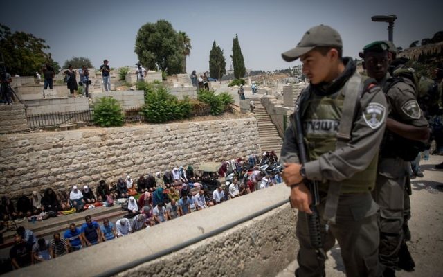 Les fidèles musulmans faisant les prières de midi par la Porte du Lion, en dehors du mont du Temple, dans la Vieille Ville de Jérusalem, le 20 juillet 2017 (Crédit : Miriam Alster / Flash90)