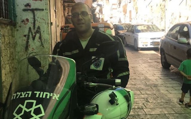 Nedal Sader assis sur son scooter d' United Hatzalah  dans la Vieille ville de Jérusalem, le 14 juillet 2017 (Crédit : Andrew Tobin)