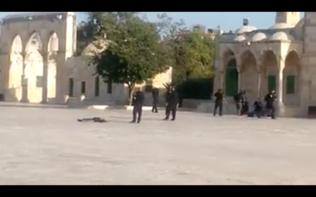 Les agents de police autour du corps d'un terroriste qui était l'un des trois hommes responsable d'un attentat à l'arme à feu qui a grièvement blessé deux Israéliens à proximité du mont du Temple dans la Vieille ville de Jérusalem, le 14 juillet 2017 (Capture d'écran) Les agents de police autour du corps d'un terroriste qui était l'un des trois hommes responsable d'un attentat à l'arme à feu qui a grièvement blessé deux Israéliens à proximité du mont du Temple dans la Vieille ville de Jérusalem, le 14 juillet 2017 (Capture d'écran)