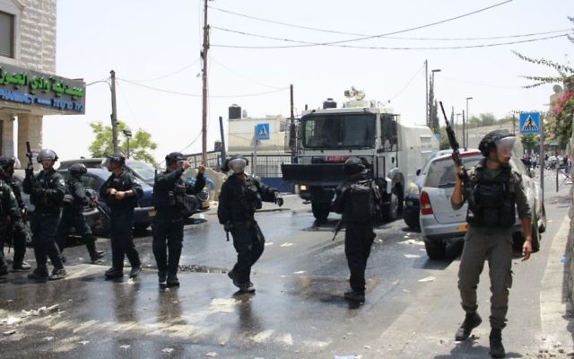 Les forces de sécurité israéliennes se tiennent devant les émeutiers palestiniens devant la porte des Lions le 21 juillet 2017 (Crédit : Judah Ari Gross / Times of Israel)