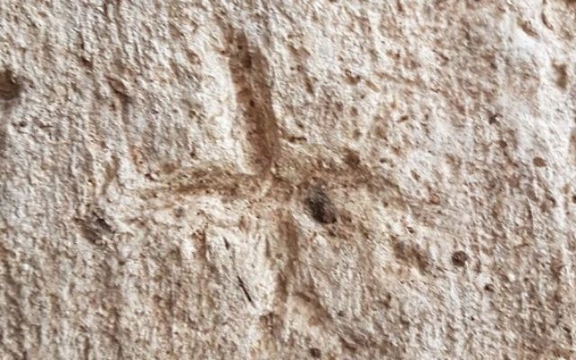 Les gravures sur les murs du réservoir d'eau de Rosh HaAyin, ici des croix. (Crédit : Gilad Itach, IAA)
