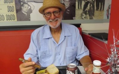 Alan Gross avec ce qu'il préfère, un sandwich au pastrami et un cigare cubain, à Loeb’s Deli à Washington DC, le 12 juillet 2017. (Crédit : Ron Kampeas)