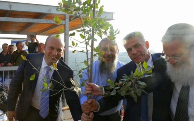 (De g à d) Le ministre de l'Education, Naftali Bennett, le président du conseil régional de Gush Etzion, Shlomo Neeman, le président de Yesh Atid, Yair Lapid, et le vice-ministre de la Défense, Eli Ben Dahan, plantent un arbre lors d'une cérémonie à l'avant-poste de Netiv Ha'avot le 23 juillet 2017. (Autorisation : Conseil régional du Gush Etzion)
Les résidents de Netiv Ha'avot protestent contre la décision de la Haute Cour de démolir 17 structures de leur avant-poste, démontrant à l'extérieur de la Knesset le 17 juillet 2017. (Jacob Magid / Times of Israel) (De g à d) Le ministre de l'Education, Naftali Bennett, le président du conseil régional de Gush Etzion, Shlomo Neeman, le président de Yesh Atid, Yair Lapid, et le vice-ministre de la Défense, Eli Ben Dahan, plantent un arbre lors d'une cérémonie à l'avant-poste de Netiv Ha'avot le 23 juillet 2017. (Autorisation : Conseil régional du Gush Etzion)
Les résidents de Netiv Ha'avot protestent contre la décision de la Haute Cour de démolir 17 structures de leur avant-poste, démontrant à l'extérieur de la Knesset le 17 juillet 2017. (Jacob Magid / Times of Israel)