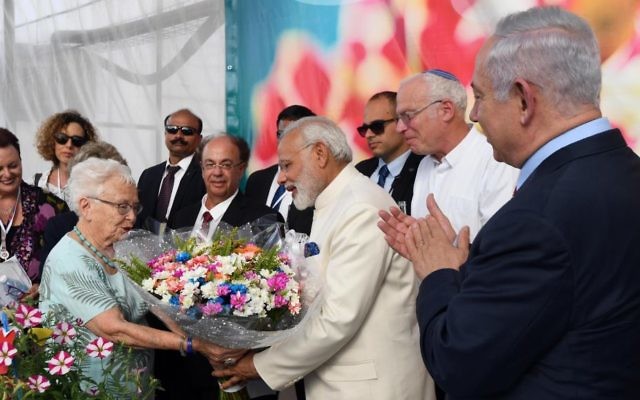 Le Premier ministre indien, au centre en blanc, reçoit un bouquet de fleurs pendant sa visite à la ferme Dan, accompagné du Premier ministre Benjamin Netanyahu, tout à droite, le 4 juillet 2017. (Crédit : Haim Tzach/GPO)