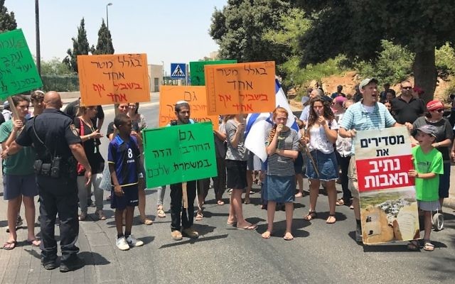 Les résidents de Netiv Ha'avot protestent contre la décision de la Haute Cour de démolir 17 structures de leur avant-poste, manifestent à l'extérieur de la Knesset le 17 juillet 2017. (Crédit : Jacob Magid / Times of Israel) Les résidents de Netiv Ha'avot protestent contre la décision de la Haute Cour de démolir 17 structures de leur avant-poste, manifestent à l'extérieur de la Knesset le 17 juillet 2017. (Crédit : Jacob Magid / Times of Israel)