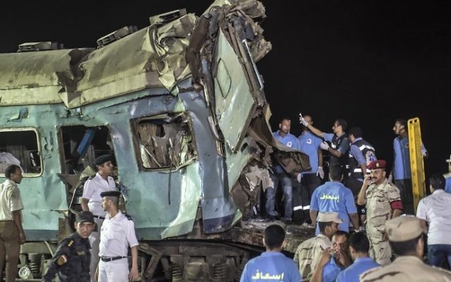 Secouristes et policiers égyptiens sur les lieux d'une catastrophe ferroviaire en Egypte, près d'Alexandrie, le 11 août 2017. (Crédit : Khaled Desouki/AFP)