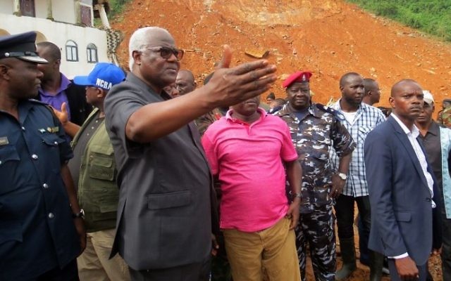 Ernest Bai Koroma, 2e à gauche, président de la Sierra Leone, sur le site d'un glissement de terrain près de Freetown, le 15 août 2017. (Crédit : Saidu Bah/AFP) Ernest Bai Koroma, 2e à gauche, président de la Sierra Leone, sur le site d'un glissement de terrain près de Freetown, le 15 août 2017. (Crédit : Saidu Bah/AFP)