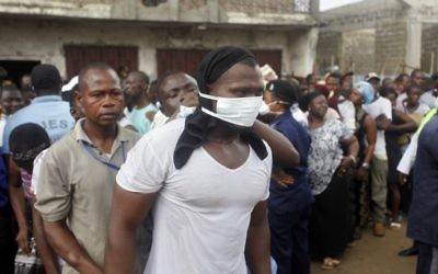 Des victimes des inondations cherchent à identifier leurs proches à la morgue de Freetown, la capitale de la Sierra Leone, le 16 août 2017. (Crédit : Saidu Bah/AFP)