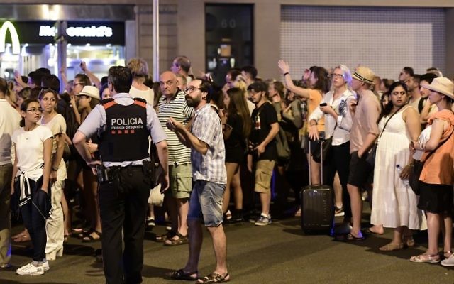 Les touristes attendent que la police les autorise à revenir dans leur hôtel sur le boulevard de Las Ramblas après un attentat au véhicule-bélier qui a tué au moins 13 personnes et fait plus d'une centaine de blessés à Barcelone, le 18 août 2017 (Crédit : JAVIER SORIANO/AFP) Les touristes attendent que la police les autorise à revenir dans leur hôtel sur le boulevard de Las Ramblas après un attentat au véhicule-bélier qui a tué au moins 13 personnes et fait plus d'une centaine de blessés à Barcelone, le 18 août 2017 (Crédit : JAVIER SORIANO/AFP)