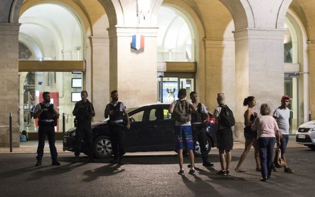 Passagers et policiers devant la gare de Nîmes après sa réouverture, le 19 août 2017. (Crédit : Jaime Reina/AFP)