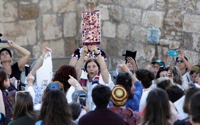 Les membres de l'association "Les femmes du mur" brandissent un rouleau de Torah durant un service de prière marquant le premier jour du mois juif d'Elul, au mur Occidental dans la Vieille Ville de Jérusalem, le 23 août 2017 (Crédit :Menahem Kahana/AFP Photo)