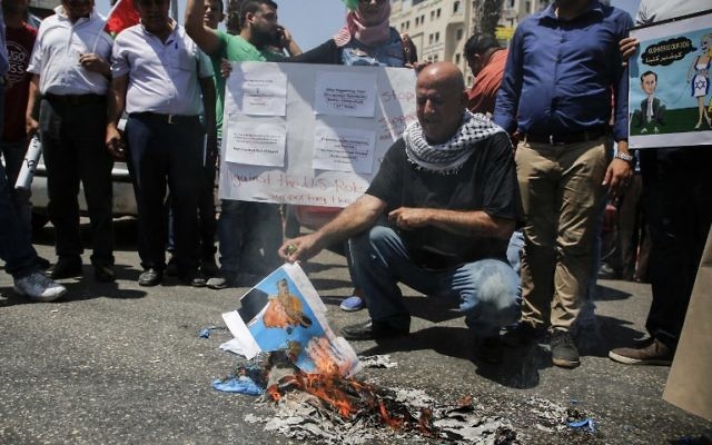 Un Palestinien brûlant un drapeau à l'effigie du président Donald Trump pendant une manifestation contre la visite d'une délégation américaine dirigée par Jared Kushner, à Ramallah, le 24 août 2017. (Crédit : Abbas Momani/AFP) Un Palestinien brûlant un drapeau à l'effigie du président Donald Trump pendant une manifestation contre la visite d'une délégation américaine dirigée par Jared Kushner, à Ramallah, le 24 août 2017. (Crédit : Abbas Momani/AFP)