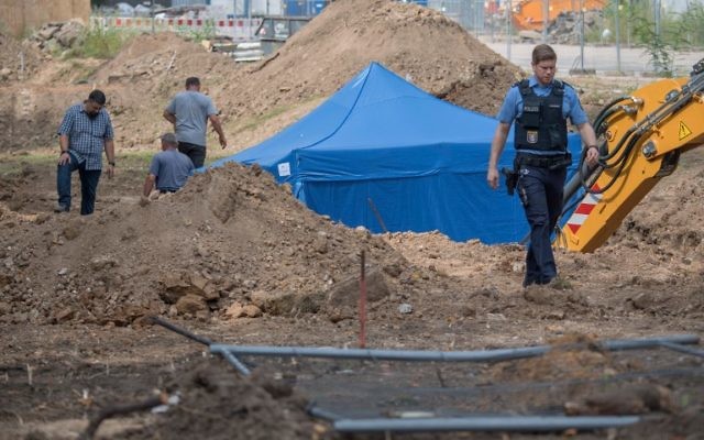 Un policier devant la tente bleue recouvrant une bombe britannique de la Seconde Guerre mondiale, retrouvée pendant des travaux à Francfort, le 30 août 2017. (Crédit : Boris Roessler/Germany OUT/dpa/AFP)