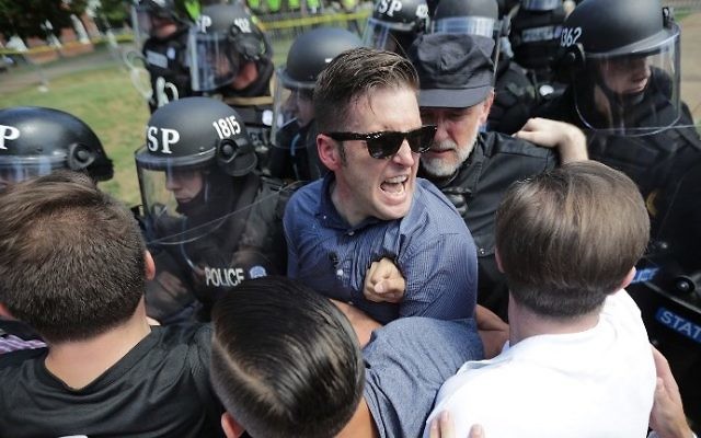 Le nationaliste blanc Richard Spencer, au centre, et ses partisans lors d'un affrontement contre la police de Virginie pendant un rassemblement d'extrême-droite à Charlottesville, le 12 août 2017. (Crédit : Chip Somodevilla/Getty Images/AFP) Le nationaliste blanc Richard Spencer, au centre, et ses partisans lors d'un affrontement contre la police de Virginie pendant un rassemblement d'extrême-droite à Charlottesville, le 12 août 2017. (Crédit : Chip Somodevilla/Getty Images/AFP)