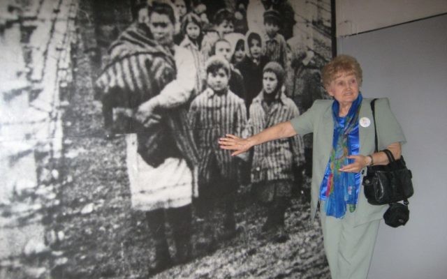 Eva Mozes Kor, jumelle de Mengele, devant sa photographie au musée du mémorial d'Auschwitz, en  2007. (Crédit : autorisation)
