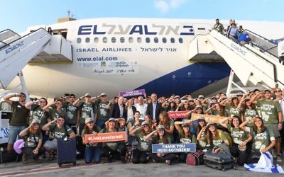 De jeunes juifs américains qui ont immigré en Israël pour entrer dans l'armée posent avec les cadres de l'organisation Nefesh B'Nefesh, au centre, après l'atterrissage de leur vol en Israël, le mardi 15 août 2017 (Crédit : Shahar Azran)