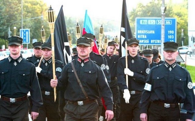 Un groupe d'extrême droite slovaque défilant à Bratislava avec leur ancien chef Marian Kotleba (au centre, en avant plan) parés d'uniformes néonazis noirs en 2016, en Slovaquie (Crédit : Matúš Tremko/Creative Commons Attribution-Share Alike 4.0 International/Wikimedia) Un groupe d'extrême droite slovaque défilant à Bratislava avec leur ancien chef Marian Kotleba (au centre, en avant plan) parés d'uniformes néonazis noirs en 2016, en Slovaquie (Crédit : Matúš Tremko/Creative Commons Attribution-Share Alike 4.0 International/Wikimedia)