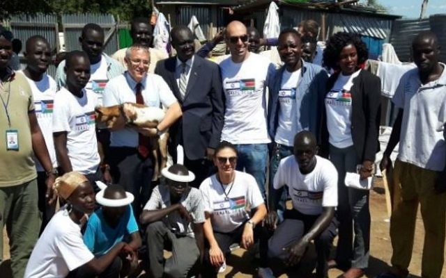 L'ambassadeur israélien au Soudan du Sud, Hanan Doger, distribue de la nourriture aux villageois aux côtés de membres du gouvernement et de représentants de groupes humanitaires israéliens, en août 2017. (Crédit : ambassade d'Israël au Soudan du Sud)