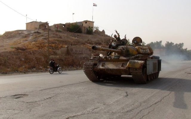 Un combattant pro-régime fait le signe de la victoire le 21 août 2016 aux commandes d'un tank dans le district du sud de Ghweiran, dans la ville de Hasakeh, au nord-est de la Syrie, face à l'avancée des forces kurdes (Crédit : AFP/STR) Un combattant pro-régime fait le signe de la victoire le 21 août 2016 aux commandes d'un tank dans le district du sud de Ghweiran, dans la ville de Hasakeh, au nord-est de la Syrie, face à l'avancée des forces kurdes (Crédit : AFP/STR)