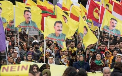 Des manifestants kurdes manifestent avec des panneaux disant "Non à la dictature" et le portrait du chef du parti des travailleurs du Kurdistan, le PKK,  Abdullah Ocalan, au centre ville de Francfort, à l'ouest de l'Allemagne, le 18 mars 2017 (Crédit : AFP Photo/dpa/Boris Roessler)
