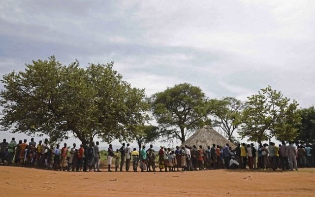 Des réfugiés qui viennent tout juste d'arriver au sud-Soudan attendent de s'inscrire à Ngomoromo, sur la frontière avec l'Ouganda, pour être transférés dans un centre de relocalisation, le 11 avril 2017 (Crédit : AFP Photo/Isaac Kasamani)