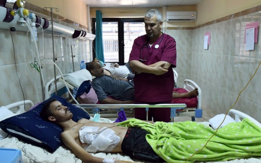 Ahmed Bougroura, à droite, médecin algérien qui dirige le service de néphrologie de l'hôpital universitaire de Batna, avec un patient greffé, le 26 juillet 2017. (Crédit : Ryad Kramdi/AFP)