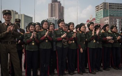 Les soldats de l'Armée populaire de Corée du nord applaudissent alors qu'ils regardent un écran montrant le lancement d'un test de missile sur une place publique, aux abords d'une gare de Pyongyang, le 30 août 2017. (Crédit : AFP/Kim Won-Jin)