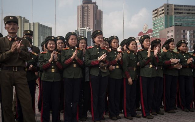 Les soldats de l'Armée populaire de Corée du nord applaudissent alors qu'ils regardent un écran montrant le lancement d'un test de missile sur une place publique, aux abords d'une gare de Pyongyang, le 30 août 2017. (Crédit : AFP/Kim Won-Jin)