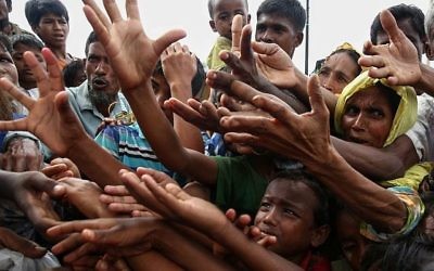 Des réfugiés Rohingyas demandent une aide alimentaire dans le camp de réfugiés de Kutupalong à Ukhiy, à proximité de la frontière entre le Myanmar et le Bangladesh, le 30 août 2017 (Crédit : Stringer/AFP)