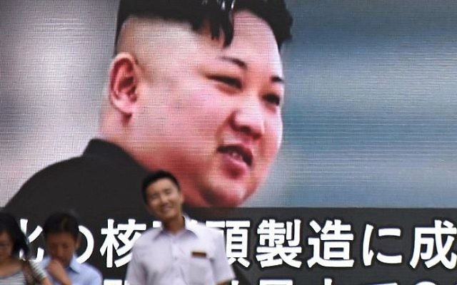 Des piétons devant une écran télévisé montrant Kim Jong-Un, le dictateur nord-coréen, à Tokyo, le 9 août 2017. (Crédit : Kazuhiro Nogi/AFP)