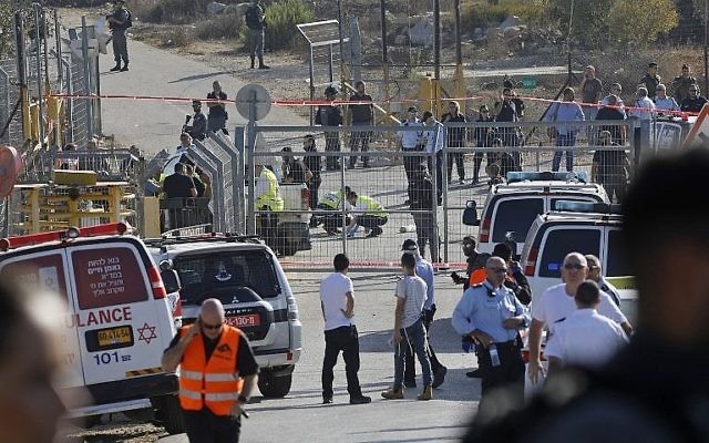 Les secouristes et les forces de sécurité sur la scène d'un attentat terroriste perpétré à l'entrée de l'implantation de Har Adar le 26 septembre 2017 (Crédit : AFP Photo/ Menahem Kahana)