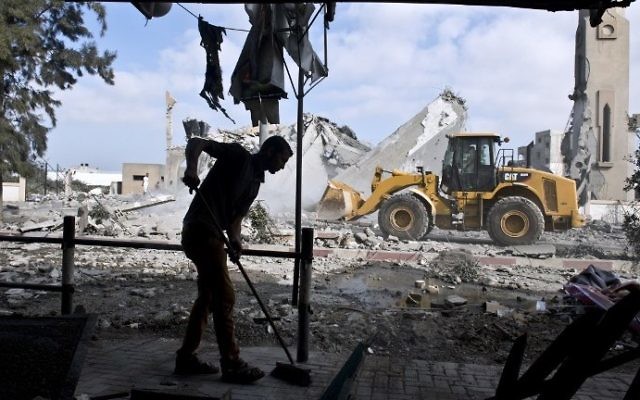 Un Palestinien balaie le sol de sa maison à Beit Lahia, dans le nord de la bande de Gaza, en août 2014. Illustration. (Crédit : Roberto Schmidt/AFP)