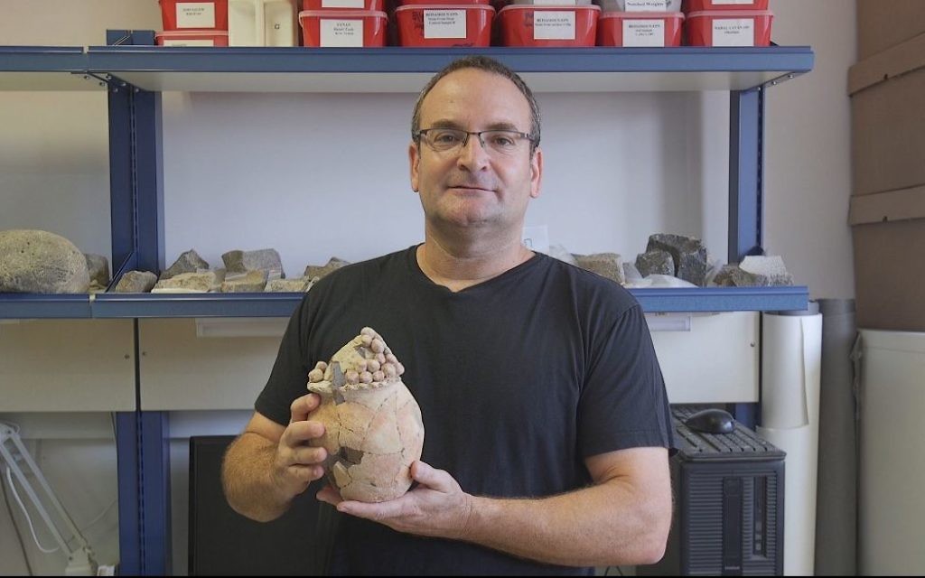 Danny Rosenberg, professeur à l'université de Haïfa, avec le modèle de silo en argile, vieux de 7 200 ans, retrouvé à Tel Tsaf, dans la vallée du Jourdain. (Crédit : Haifa University)