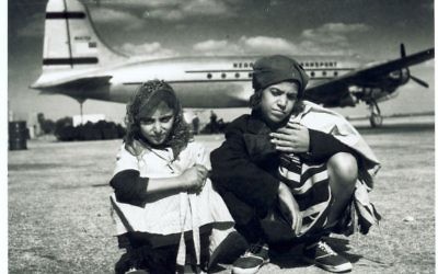 Enfants yéménites arrivés en Israël grâce à l'opération Tapis volant, devant un avion d'Alaska Airlines. (Crédit : AJM)