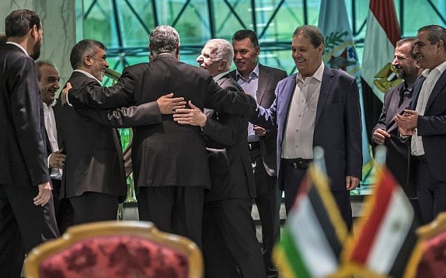 Khaled Fawzi, 3ème à gauche, chef des services égyptiens de renseignement, s'esclaffe aux côtés du leader du Hamas, Izzat al-Rishq, 2ème à gauche, et d'Azzam al-Ahmad du Fatah, au centre, suite à la signature de l'accord de réconciliation au Caire, le 12 octobre 2017 (Crédit :AFP / KHALED DESOUKI) Khaled Fawzi, 3ème à gauche, chef des services égyptiens de renseignement, s'esclaffe aux côtés du leader du Hamas, Izzat al-Rishq, 2ème à gauche, et d'Azzam al-Ahmad du Fatah, au centre, suite à la signature de l'accord de réconciliation au Caire, le 12 octobre 2017 (Crédit :AFP / KHALED DESOUKI)