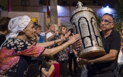 Des Juifs marocains et des touristes juifs israéliens pendant la fête de Simchat Torah à la synagogue de Marrakech, le 12 octobre 2017. (Crédit : Fadel Senna/AFP)
