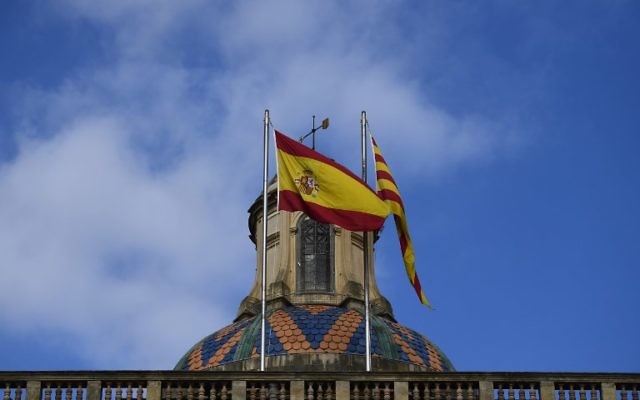 Les drapeaux espagnol, à gauche, et catalan à Barcelone, le 28 octobre 2017. (Crédit : Pierre-Philippe Marcou/AFP)
