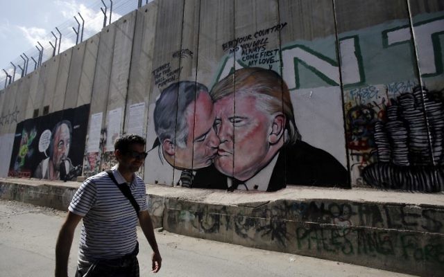 Baiser entre le Premier ministre Benjamin Netanyahu et le président américain Donald Trump sur la barrière de sécurité de Cisjordanie, à Bethléem, le 29 octobre 2017. (Crédit : Musa al Shaer/AFP) Baiser entre le Premier ministre Benjamin Netanyahu et le président américain Donald Trump sur la barrière de sécurité de Cisjordanie, à Bethléem, le 29 octobre 2017. (Crédit : Musa al Shaer/AFP)