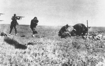 Une femme tente de protéger un enfant avec son propre corps juste avant leur exécution par un escadron de la mort nazi  (Einsatzgruppen) à proximité d'Ivangorod, en Ukraine, en 1942. (Crédit : Wikimedia commons)